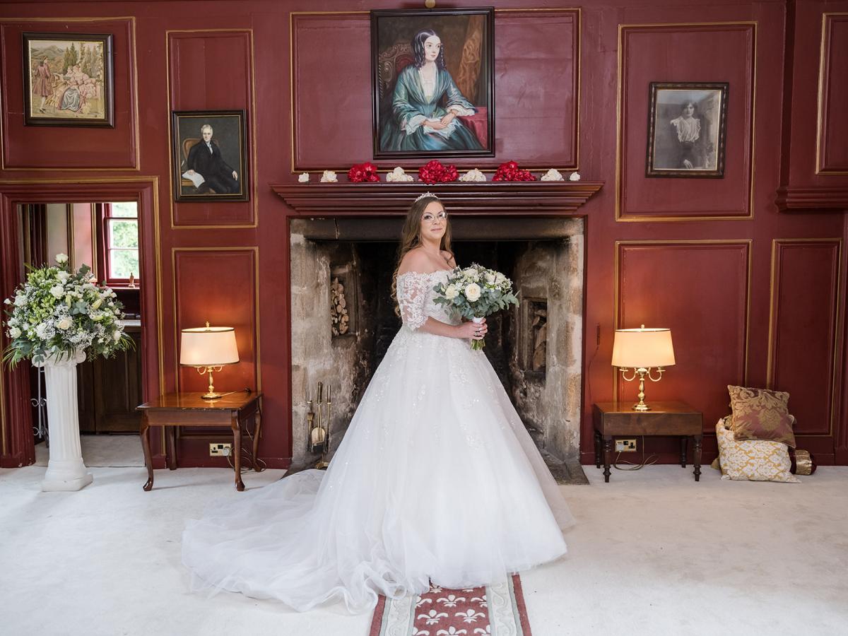 Bride in front of fireplace at Lickelyhead Castle